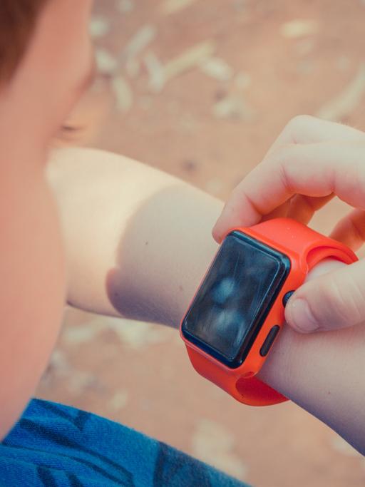 Ein Kind bedient eine Smartwatch. 