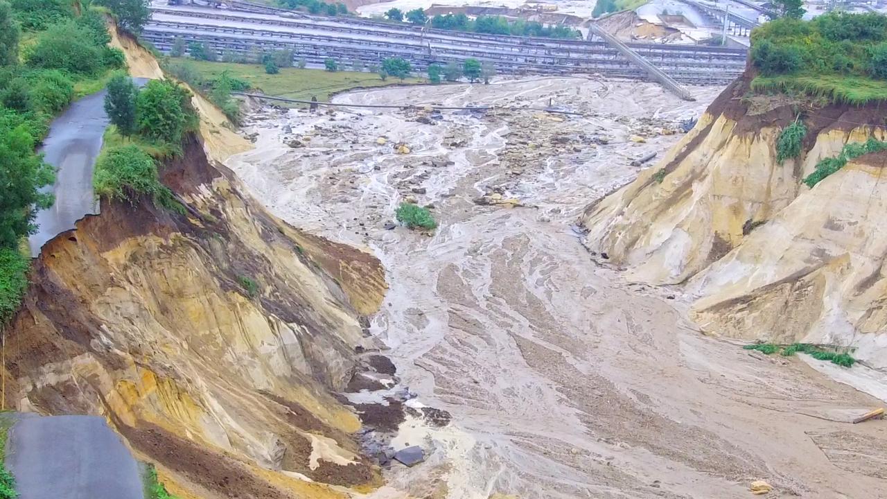 Wasser fließt in den Tagebau Inden, nachdem der Hochwasser führende Fluss Inde einen Deich in der Nähe des Braunkohletagebaus Inden bei Aachen überspült hat Wasser fließt in den Tagebau Inden, nachdem der Hochwasser führende Fluss Inde einen Deich in der Nähe des Braunkohletagebaus Inden bei Aachen überspült hat
