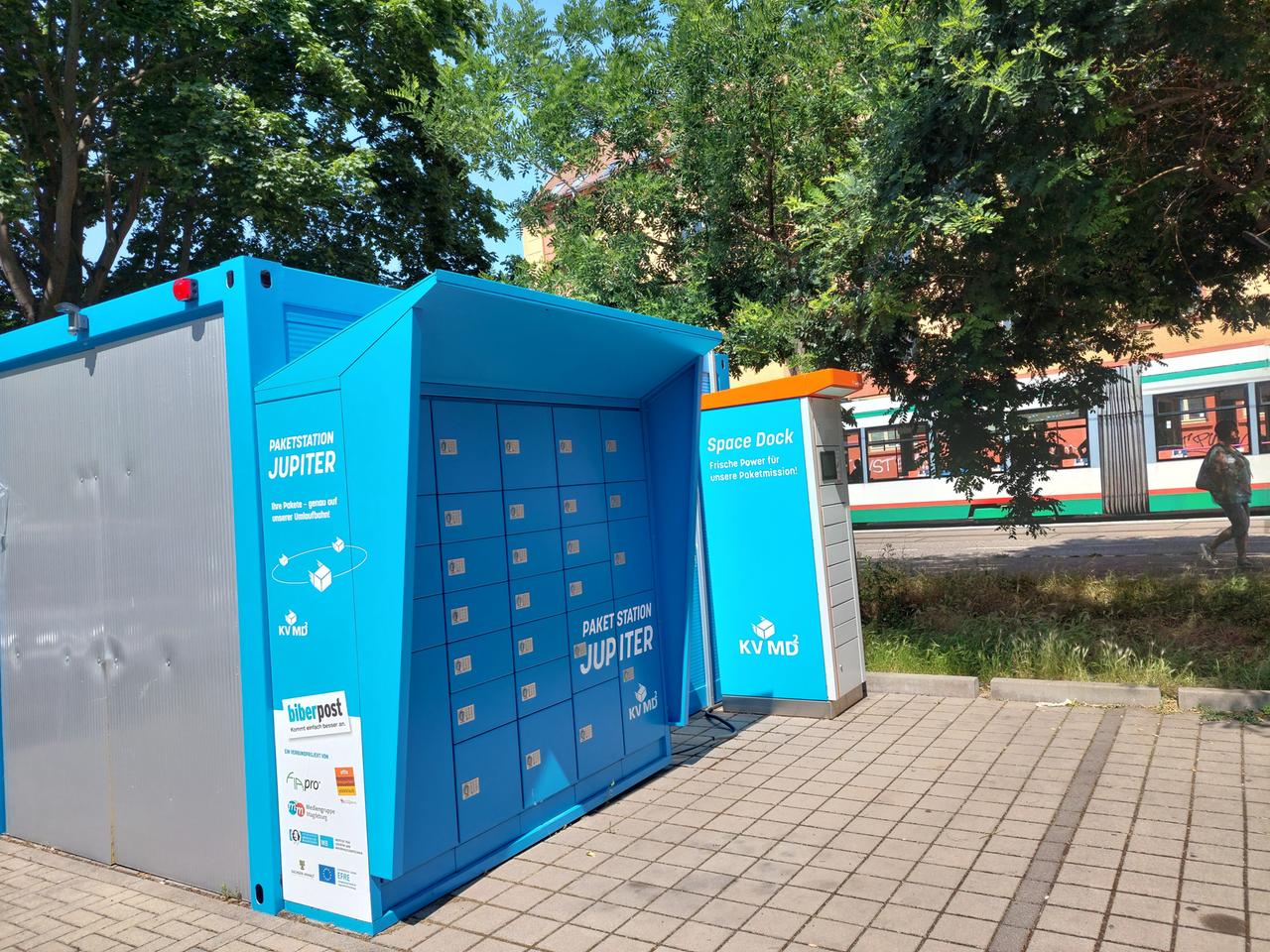 Eine Paketstation in Magedburg, im Hintergrund eine Straßenbahn Eine Paketstation in Magedburg, im Hintergrund eine Straßenbahn