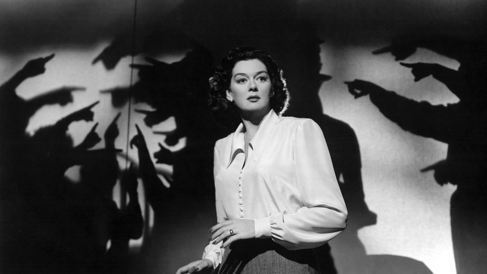Rosalind Russell in einer Filmszene ca. 1947, in der mehrere Handschatten auf sie zeigen und sie umzingeln. Rosalind Russell in einer Filmszene ca. 1947, in der mehrere Handschatten auf sie zeigen und sie umzingeln.