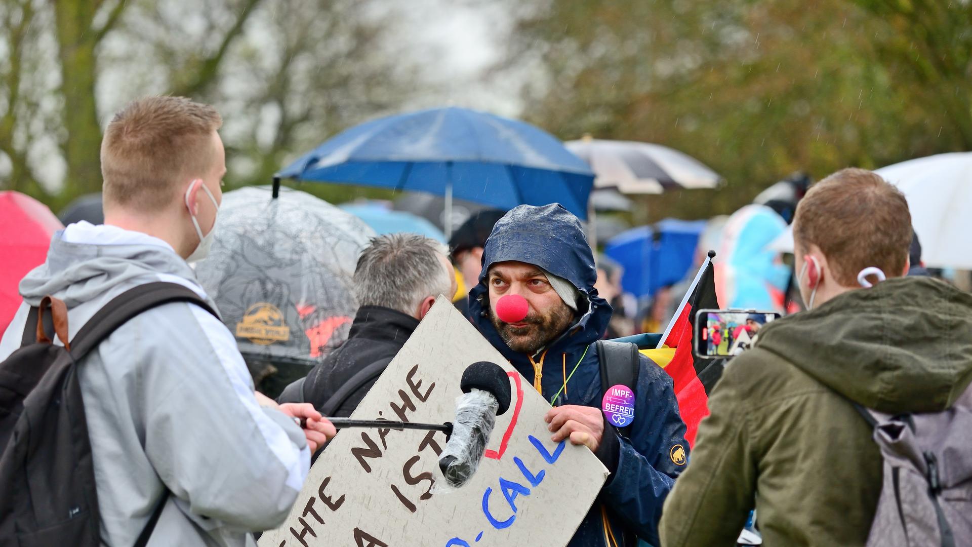 Im Bild, ein Teilnehmer einer Querdenken Demonstration in April 2021 mit Clownnase gibt Journalisten ein Interview. Im Bild, ein Teilnehmer einer Querdenken Demonstration in April 2021 mit Clownnase gibt Journalisten ein Interview.