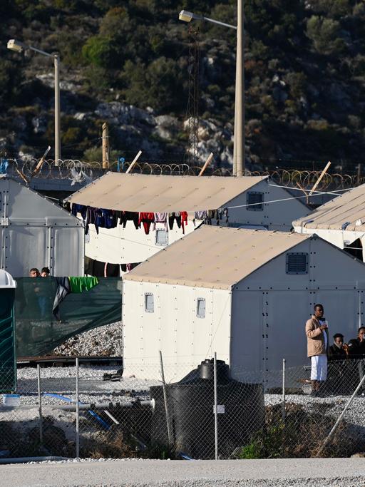 Mehrere provisorische Zelte stehen im Flüchtlingslager Moria auf der griechischen Insel Lesbos, vor einigen stehen Migranten. 