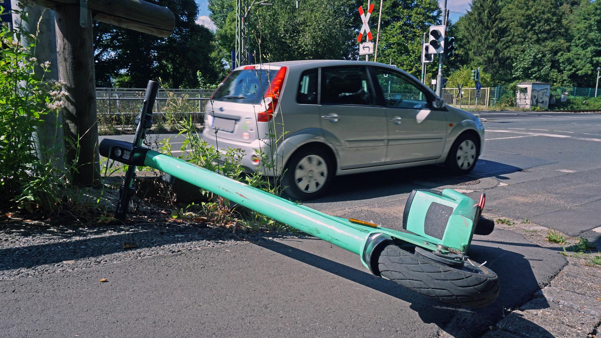 Elektro-Tretroller in der Stadt Ein sogenannter E-Scooter liegt umgeworfen auf einem Bürgersteig am Straßenrand Essen Nordrhein-Westfalen Deutschland. Elektro-Tretroller in der Stadt Ein sogenannter E-Scooter liegt umgeworfen auf einem Bürgersteig am Straßenrand Essen Nordrhein-Westfalen Deutschland.