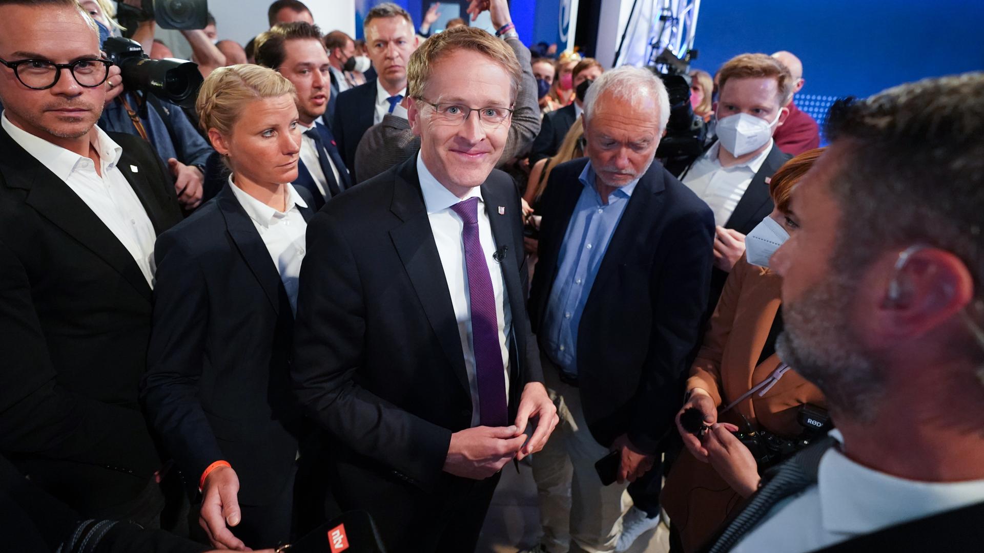 Daniel Günther (CDU), Ministerpräsident von Schleswig-Holstein, umringt von mehreren Menschen Daniel Günther (CDU), Ministerpräsident von Schleswig-Holstein, umringt von mehreren Menschen