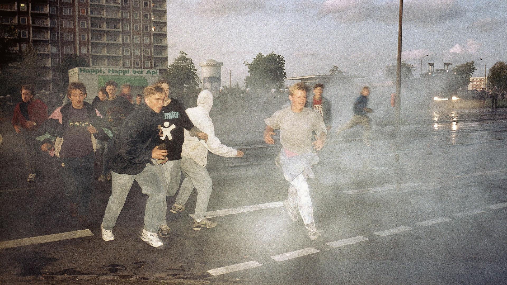 Demonstrierende rechtsextreme Jugendliche in Rostock im Strahl von Wasserwerfern der Polizei, Spätersommer 1992. Demonstrierende rechtsextreme Jugendliche in Rostock im Strahl von Wasserwerfern der Polizei, Spätersommer 1992.