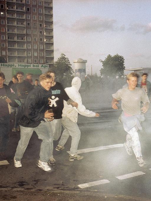 Demonstrierende rechtsextreme Jugendliche in Rostock im Strahl von Wasserwerfern der Polizei, Spätersommer 1992.