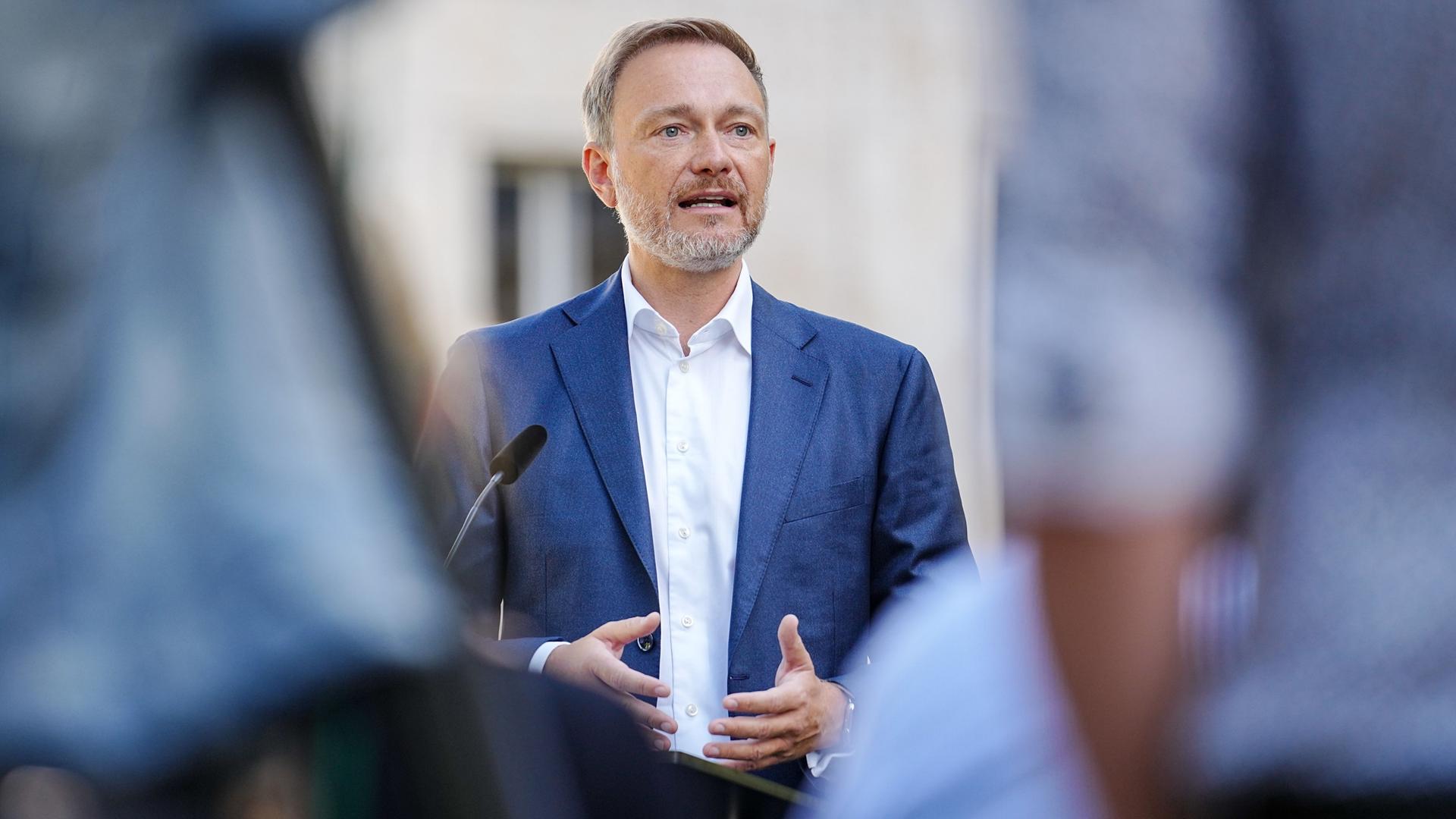 Christian Lindner (FDP), Bundesminister der Finanzen, steht hinter einem Mikrofon und spricht mit Journalisten. Christian Lindner (FDP), Bundesminister der Finanzen, steht hinter einem Mikrofon und spricht mit Journalisten.