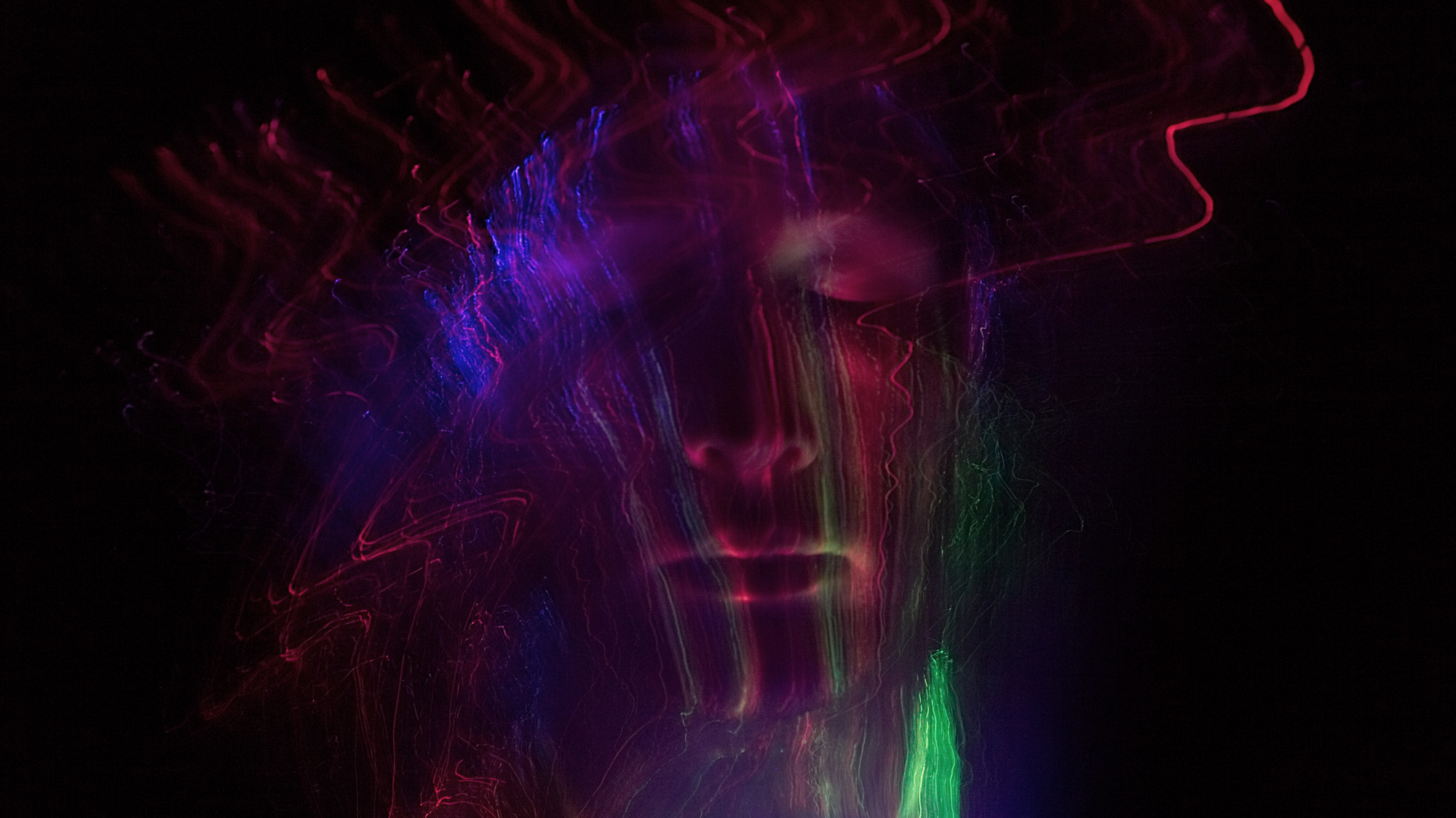 Künstliche Intelligenz. Zu sehen: Ein männliches Gesicht umhüllt von Laserstrahlen. Dunkler Hintergrund.