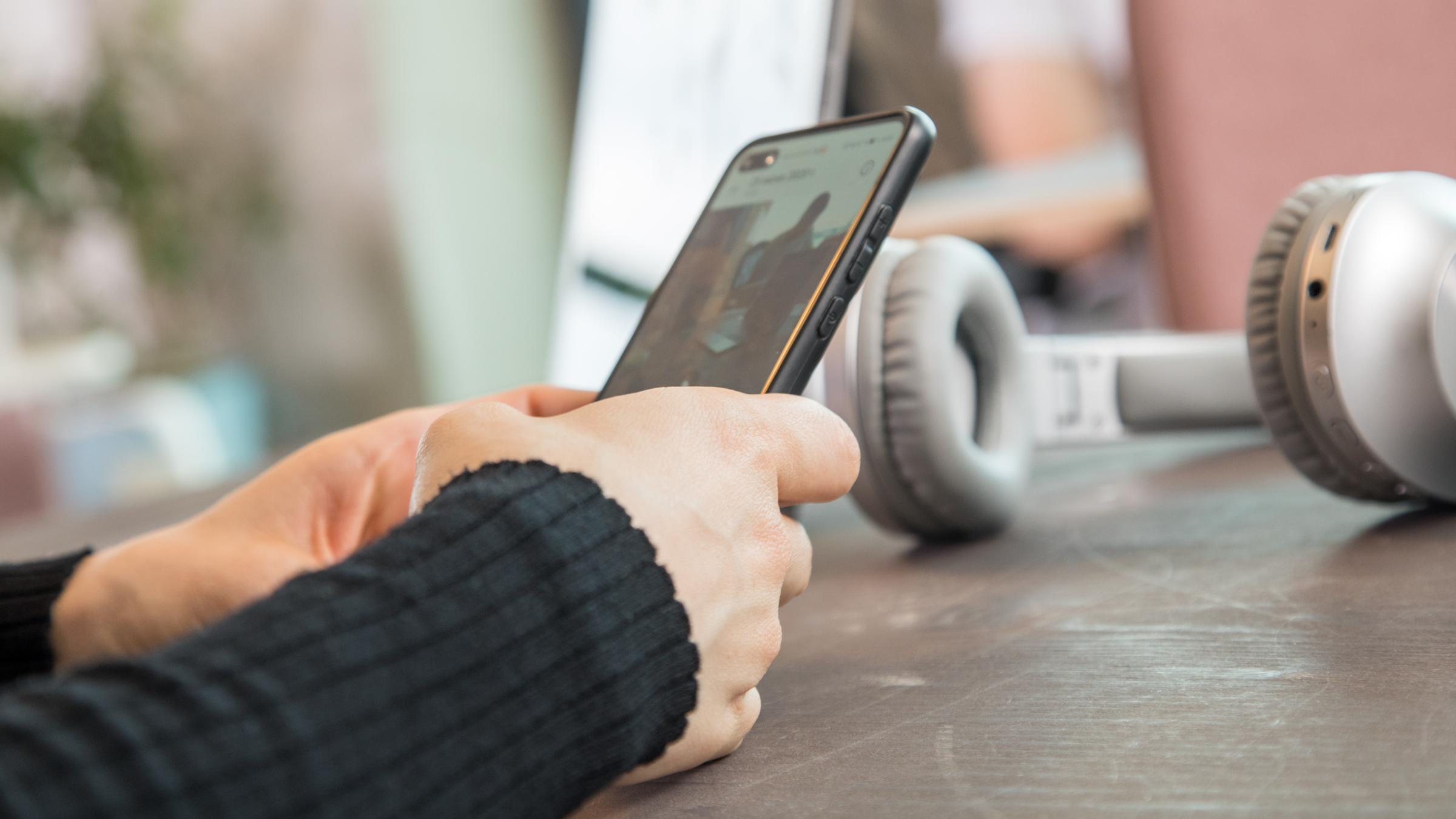 Eine Frau schaut in einem Coworking Space auf ihr Smartphone.