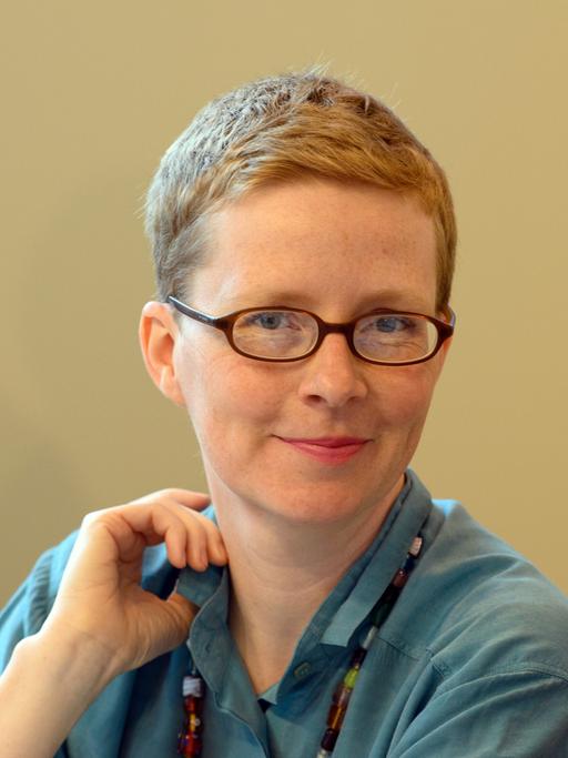 Die Schriftstellerin Judith Zander lächelt mit Brille und kurzen Haaren in die Kamera.