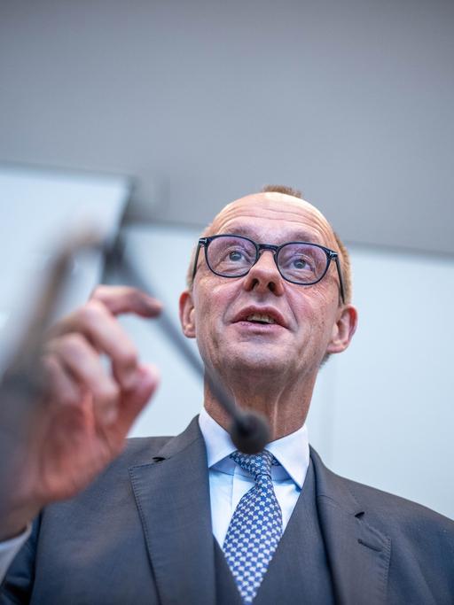 Friedrich Merz, CDU-Bundesvorsitzender, spricht zu Beginn der Fraktionssitzung der CDU/CSU-Fraktion im Bundestag. Die Kamera zeigt ihn von schräg unten. Er gestikuliert mit der rechten Hand.