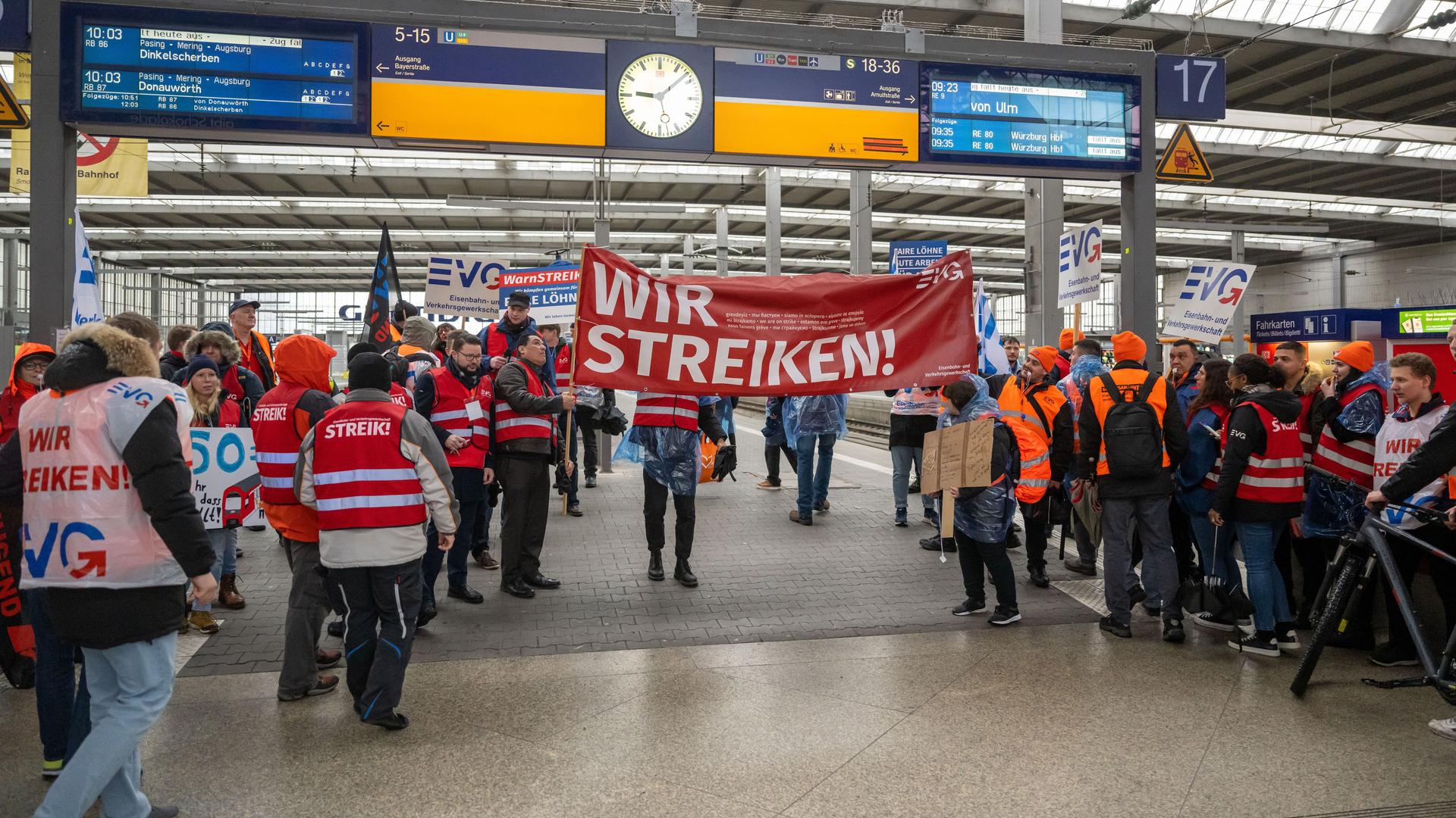 Mit Plakaten und Bannern ziehen Mitglieder der Menschen protestieren am Haupt-Bahnhof in der Stadt München und halten Plakate hoch. Mit Plakaten und Bannern ziehen Mitglieder der Menschen protestieren am Haupt-Bahnhof in der Stadt München und halten Plakate hoch.