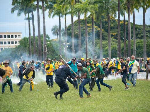 Ein Mann schlägt dabei einen Polizisten mit einer Stange. Anhänger des ehemaligen brasilianischen Präsidenten Jair Bolsonaro haben den Kongress in der Hauptstadt Brasilia gestürmt.