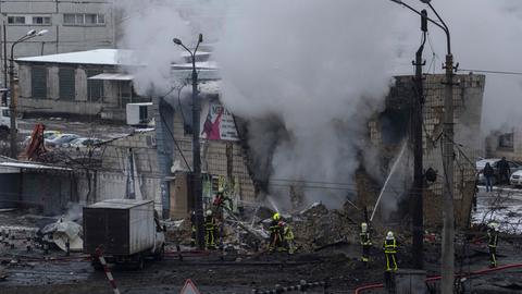 Kiew: Die ukrainische Feuerwehr löscht ein Gebäude, das durch eine russische Rakete zerstört wurde.