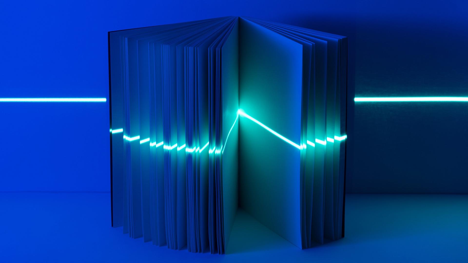 Ein geöffnetes Buch mit einem Lichtstrahl wie ein Laser, quer durch alle Seiten. Ein geöffnetes Buch mit einem Lichtstrahl wie ein Laser, quer durch alle Seiten.
