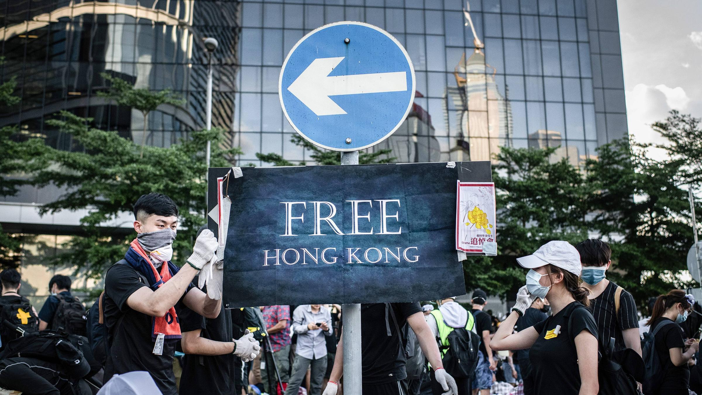 Protestierende befestigen am 01.07.2019 ein Plakat mit der Aufschrift "Free Hongkong" an einem Verkehrsschild vor dem Legislativrat in Hongkong.