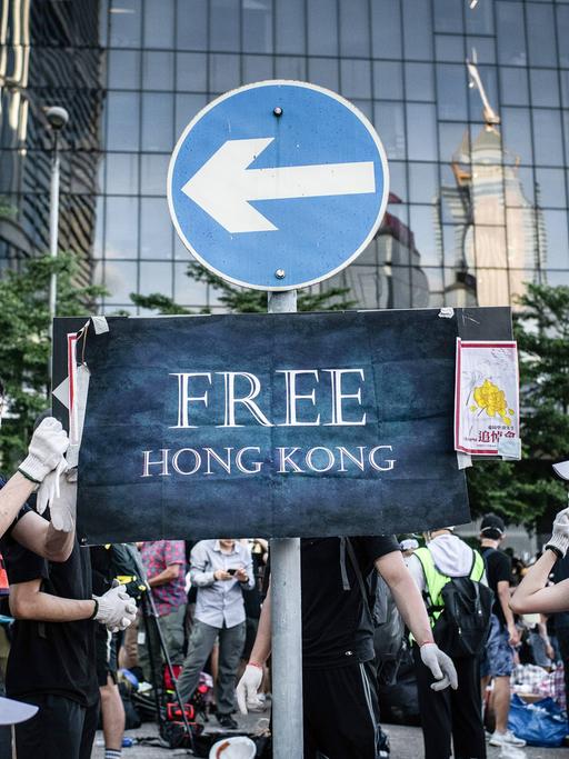 Protestierende befestigen am 01.07.2019 ein Plakat mit der Aufschrift "Free Hongkong" an einem Verkehrsschild vor dem Legislativrat in Hongkong.