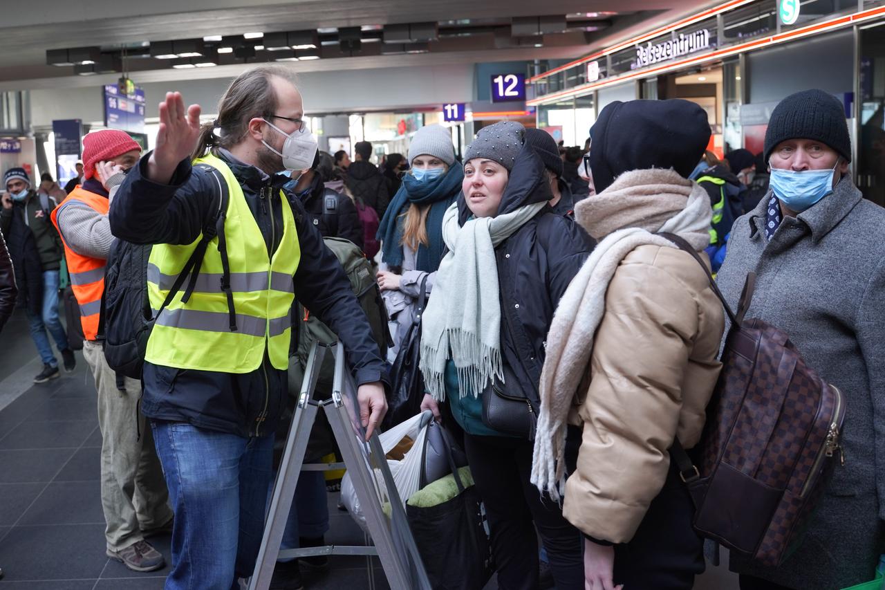 Il volontario Marcel, un ingegnere del congedo parentale, spiega ai rifugiati appena arrivati ​​alla stazione centrale di Berlino come raggiungere l'Ufficio statale per gli affari dei rifugiati (LAF) o come ottenere i biglietti del treno per continuare il loro viaggio. 