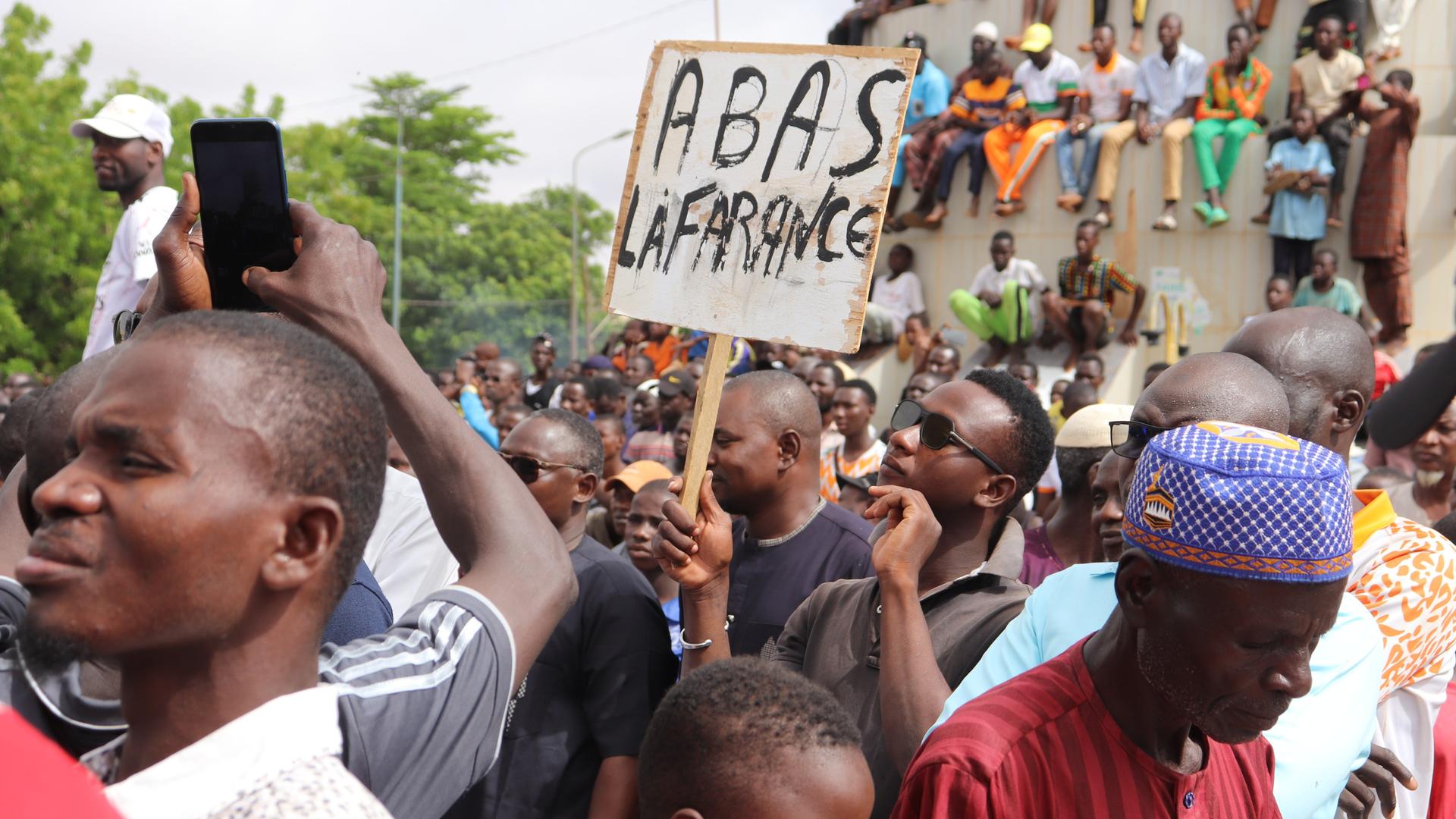 Menschen demonstrieren in Nigers Hauptstadt Niamey, um damit ihre Unterstützung für die Putschisten zu zeigen. Ein junger Mann hält dabei ein Schild mit der Aufschrift «A bas la France» (Nieder mit Frankreich) hoch. Bei der Demonstration wurden auch Parolen gegen die ehemalige Kolonialmacht Frankreich gerufen Menschen demonstrieren in Nigers Hauptstadt Niamey, um damit ihre Unterstützung für die Putschisten zu zeigen. Ein junger Mann hält dabei ein Schild mit der Aufschrift «A bas la France» (Nieder mit Frankreich) hoch. Bei der Demonstration wurden auch Parolen gegen die ehemalige Kolonialmacht Frankreich gerufen