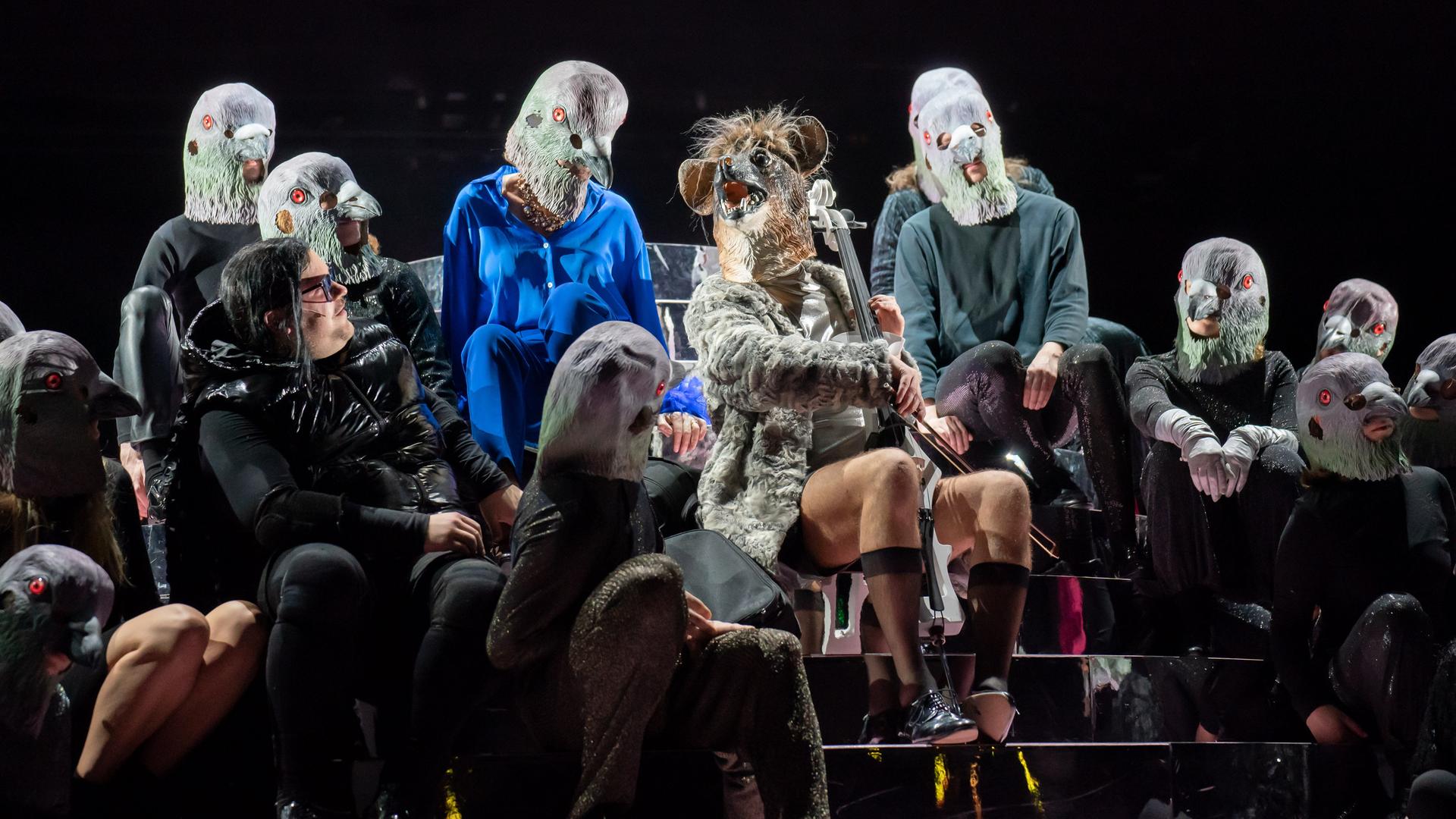 Bühnenszene aus der Operette "Die Rache der Fledermaus" am Thalia Theater. Björn Meyer sitzt mit Fledermausmaske in der Mitte, umrahmt von mehreren Darstellerinnen und Darstellern.