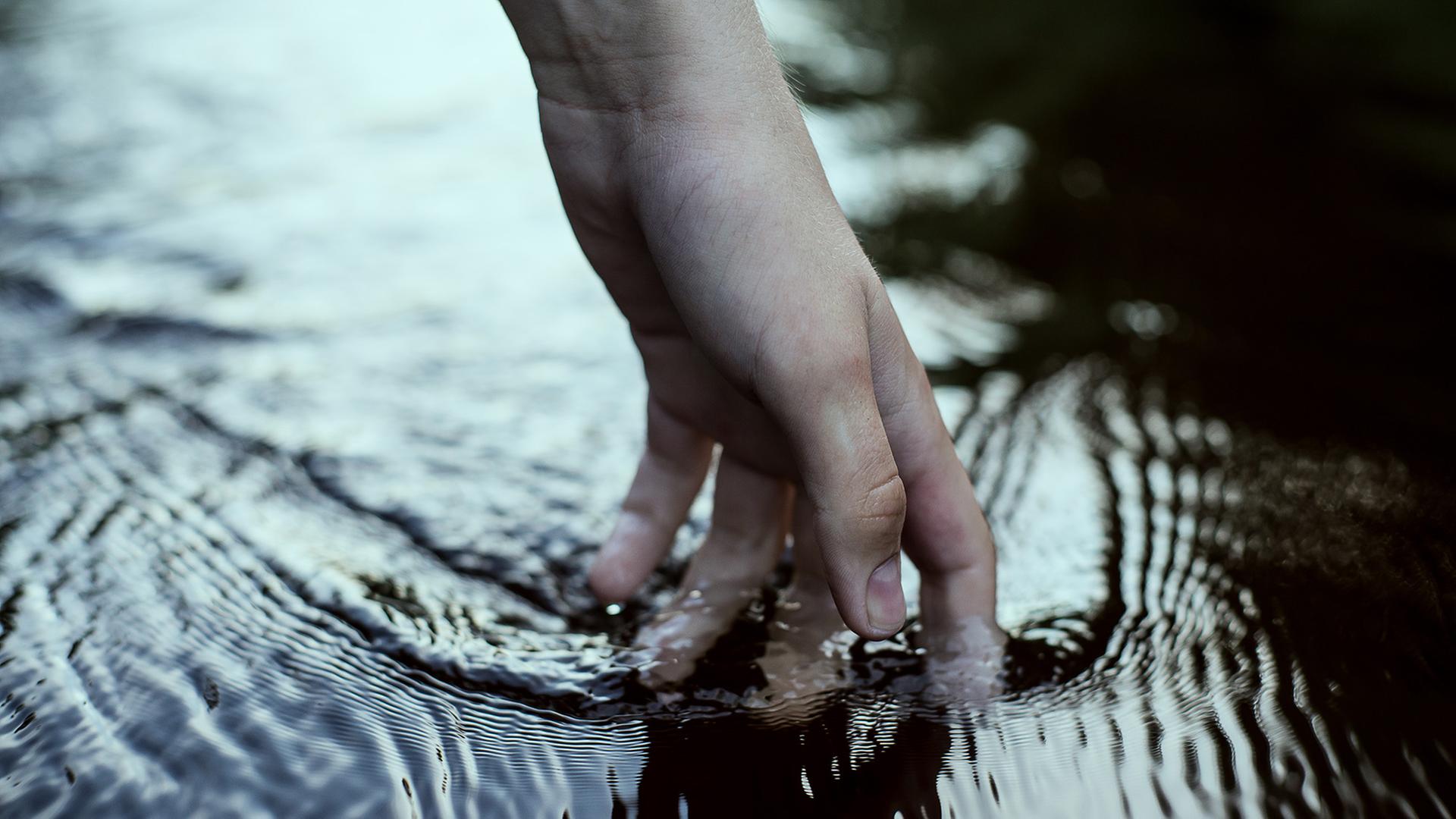 Eine Hand im Wasser. Eine Hand im Wasser.