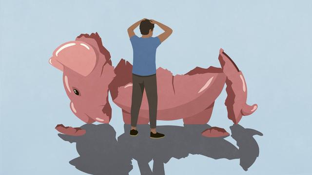 Ein gestresster Mann schaut auf ein übergroßes leeres zerschlagenes Sparschwein.