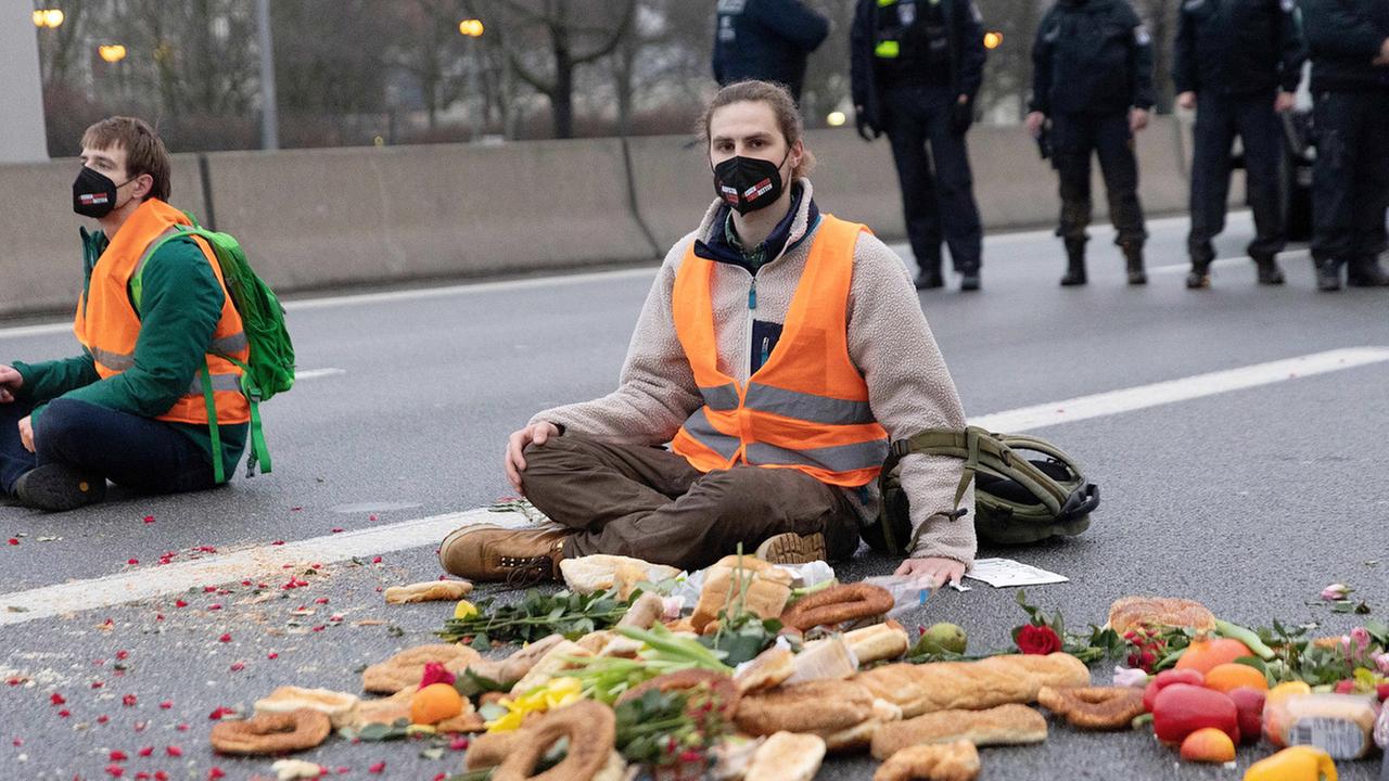 Klimaaktivisten bei einer Autobahnblockade, sie sitzen auf dem Aspalt und haben sich mit Sekundenkleber die Hände am Boden festgeklebt, 04.02.2022. Klimaaktivisten bei einer Autobahnblockade, sie sitzen auf dem Aspalt und haben sich mit Sekundenkleber die Hände am Boden festgeklebt, 04.02.2022.