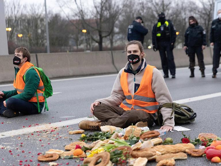 Klimaaktivisten bei einer Autobahnblockade, sie sitzen auf dem Aspalt und haben sich mit Sekundenkleber die Hände am Boden festgeklebt, 04.02.2022.