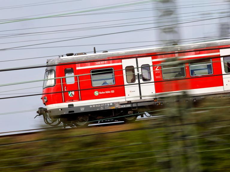 Eine S-Bahn der Deutschen Bahn fährt auf einem Gleis nahe des Bahnhof Köln.