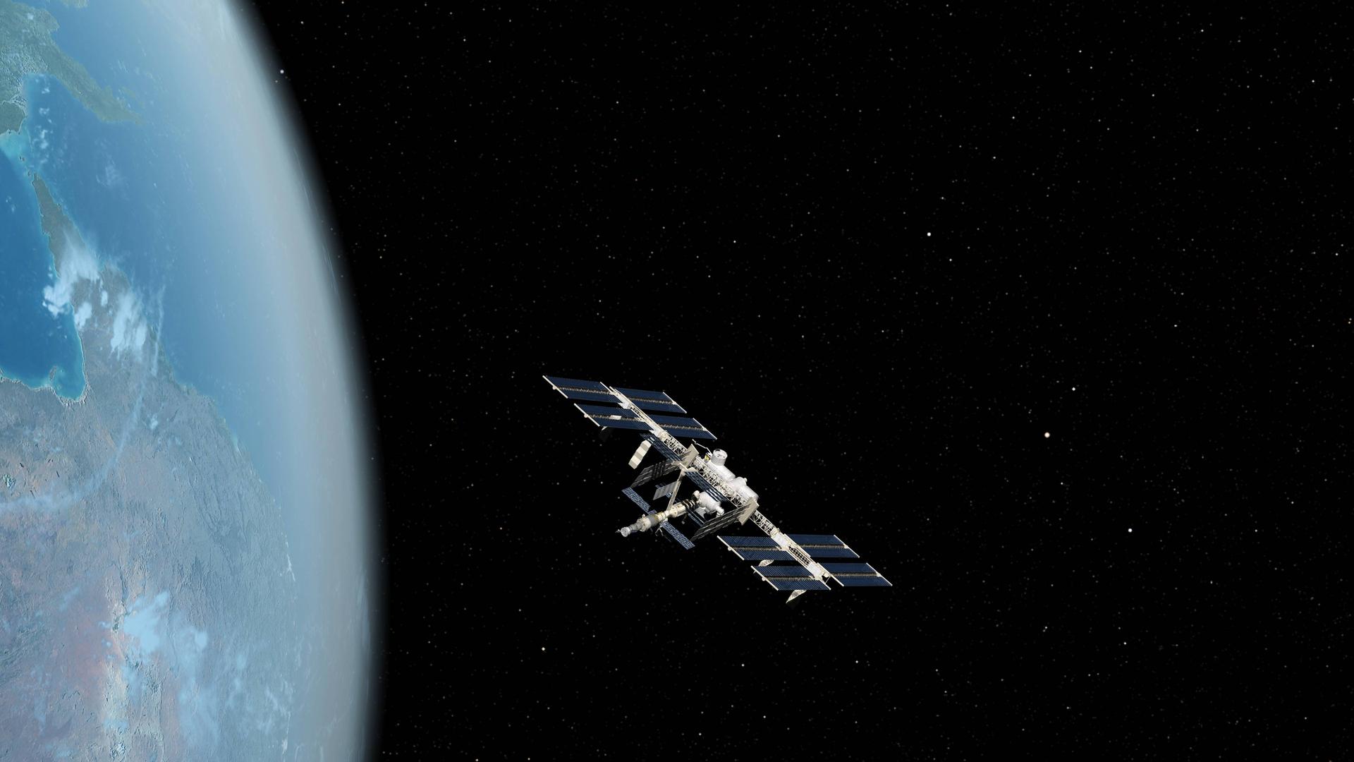 Die ISS fliegt durch das All. Am linken Bildrand ist die Erdkrümmung zu sehen. Die ISS fliegt durch das All. Am linken Bildrand ist die Erdkrümmung zu sehen.