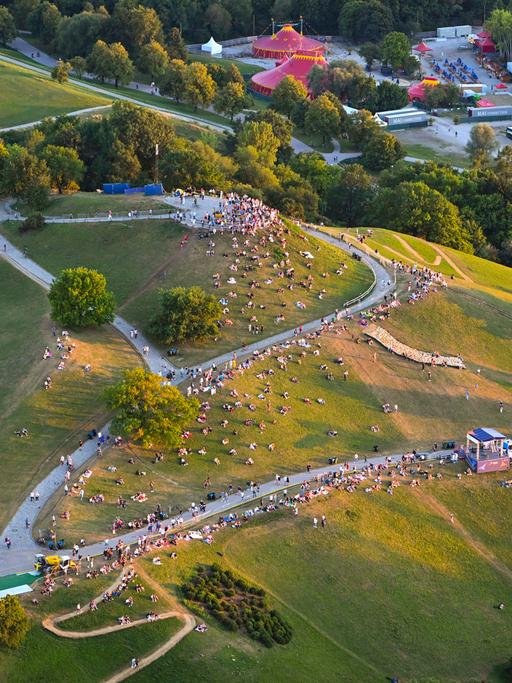 Grüne Hügel mit Menschen darauf: Blick auf den Olympiapark München.