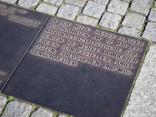 Eine Metallplakette erinnert an die Bücherverbrennung vom 10. Mai 1933 und würdigt die von den Nationalsozialisten verfolgten Schriftsteller, Wissenschaftler und Philosophen.