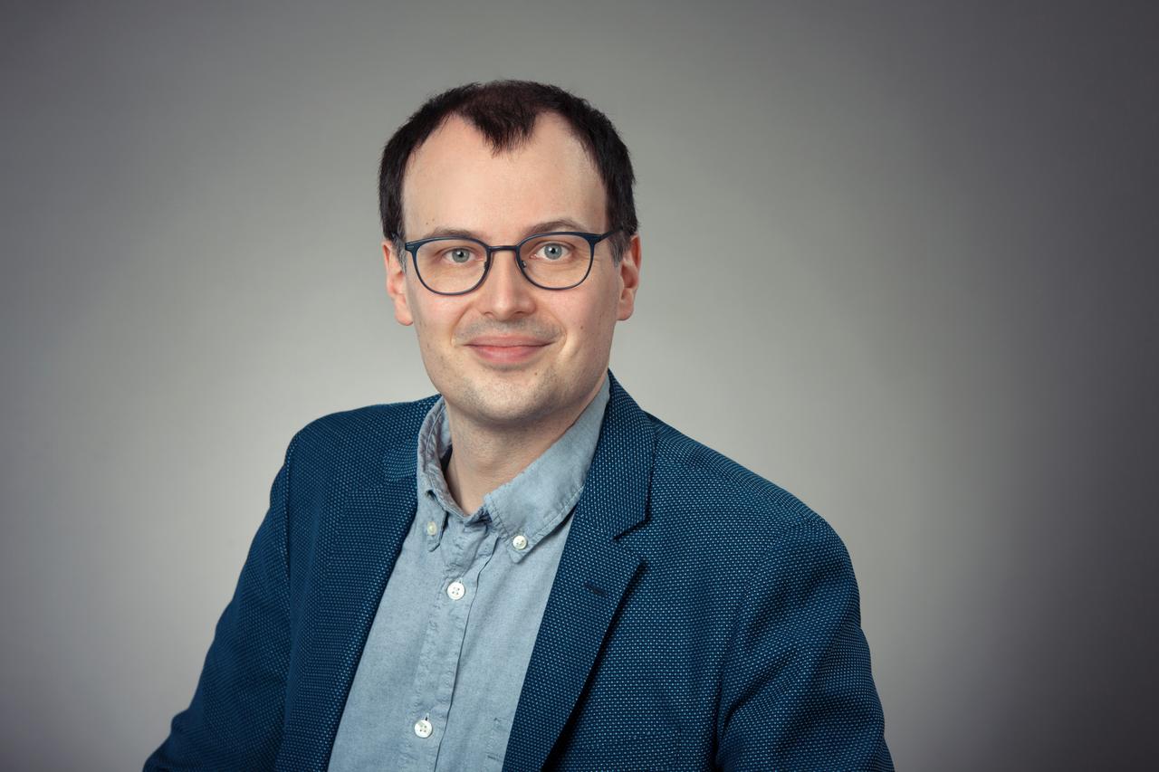 Johannes Müller-Salo, im blauen Sakko und mit Brille, lächelt freundlich in die Kamera. Johannes Müller-Salo, im blauen Sakko und mit Brille, lächelt freundlich in die Kamera.