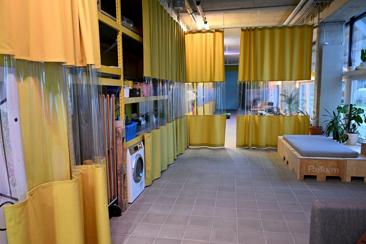 Blick in die mit Vorhängen unterteilte Lobby. Diese wird als Wartebereich und Waschküche genutzt.