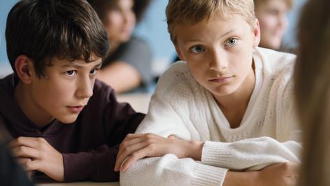 Filmstill aus "Close", zwei Jungen, die beiden Hauptdarsteller: Rémi (Gustav De Waele) und Léo (Eden Dambrine) sitzen vertraulich nebeneinander.