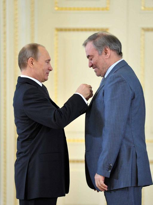 Wladimir Putin steckt dem Dirigenten Waleri Gergijew eine Ehrennadel ans Revers.