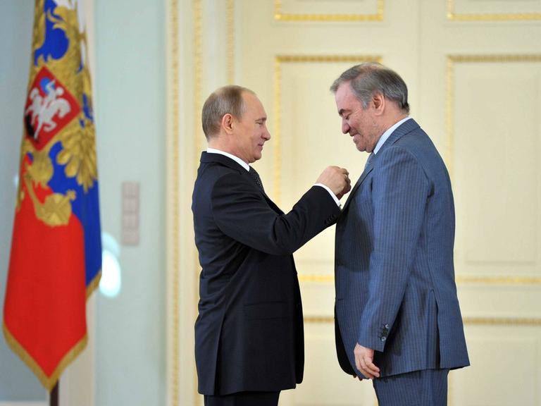 Wladimir Putin steckt dem Dirigenten Waleri Gergijew eine Ehrennadel ans Revers.