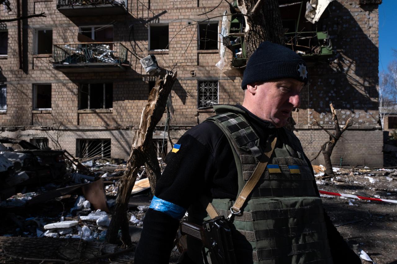 Ein ukrainischer Soldat läuft vor einem zerstört Wohnblock entlang. Ein ukrainischer Soldat läuft vor einem zerstört Wohnblock entlang.