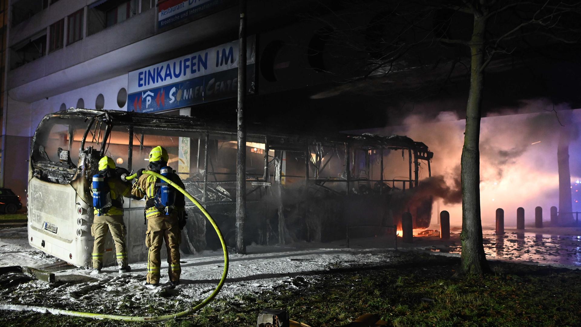 Einsatzkräfte der Feuerwehr löschen in der Silvesternacht an der Sonnenallee im Bezirk Neukölln einen brennenden Bus, der von Unbekannten angezündet worden war. Einsatzkräfte der Feuerwehr löschen in der Silvesternacht an der Sonnenallee im Bezirk Neukölln einen brennenden Bus, der von Unbekannten angezündet worden war.
