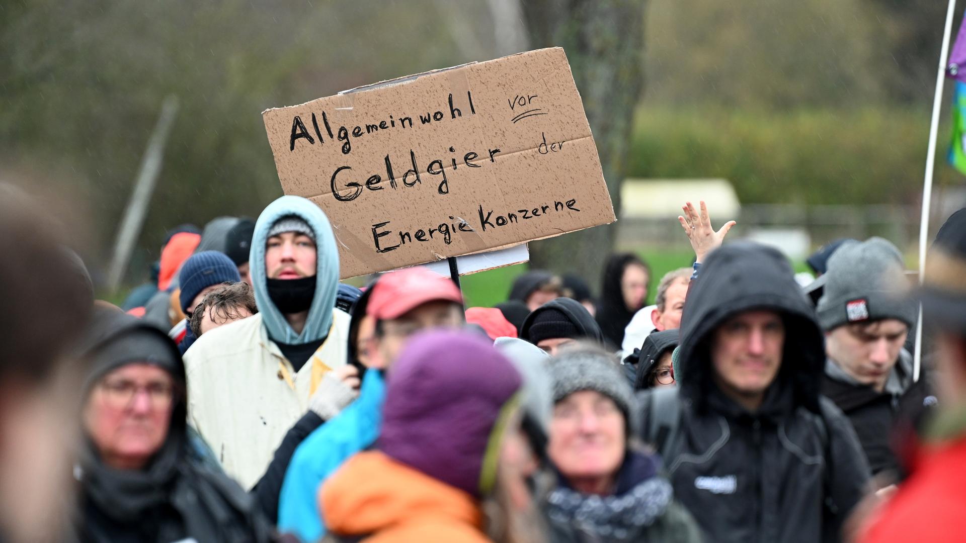 Demonstranten halten ein Schild mit der Aufschrift "Allgemeinwohl vor Geldgier der Energiekonzerne". Die Demonstration von Klimaaktivisten bei Lützerath findet unter dem Motto "Räumung verhindern! Für Klimagerechtigkeit" statt.