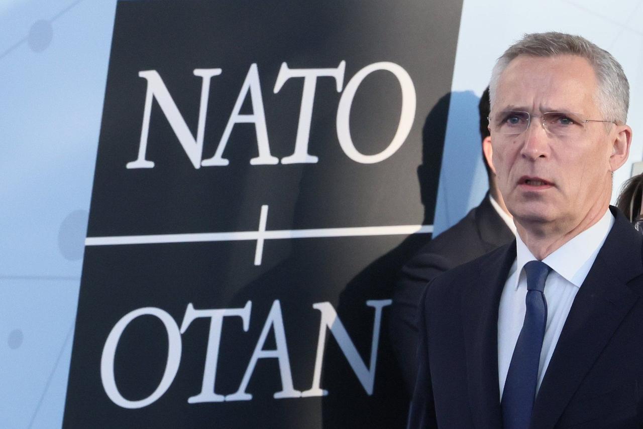 Jens Stoltenberg, Nato-Generalsekretär, spricht mit Journalisten als er zum Nato-Sondergipfel eintrifft. Neben ihm das NATO-Logo an einer Wand.