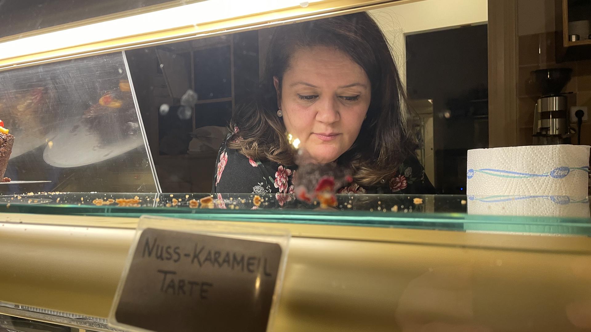Halise Olucu-Ekinler ist über eine Kuchentheke gelehnt. Halise Olucu-Ekinler ist über eine Kuchentheke gelehnt.