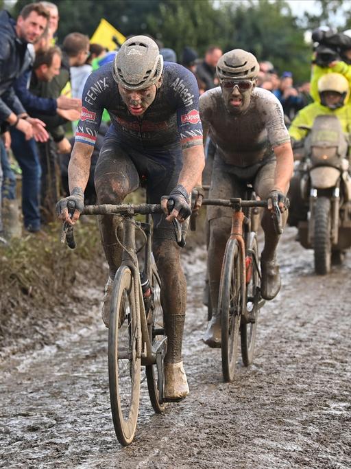 Mit Schlamm verschmierte Radfahrer bei dem Radklassiker Paris-Roubaix
