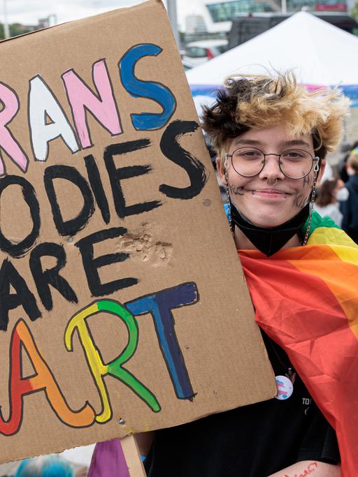 Noah hält auf der Demonstration zum Christopher Street Day (CSD) im Juli 2022 in Kiel ein Schild mit der Aufschrift "Trans Bodies Are Art"