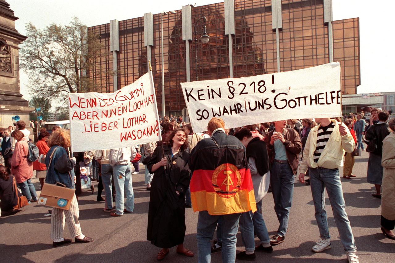 DDR-Bürger mit Transparenten wie "Kein §218! So wahr und Gott helfe" und "Wenn der Gummi aber nun ein Loch hat lieber Lothar was dann?" vor der Volkskammer in Ostberlin am 22. April 1990. DDR-Bürger mit Transparenten wie "Kein §218! So wahr und Gott helfe" und "Wenn der Gummi aber nun ein Loch hat lieber Lothar was dann?" vor der Volkskammer in Ostberlin am 22. April 1990.
