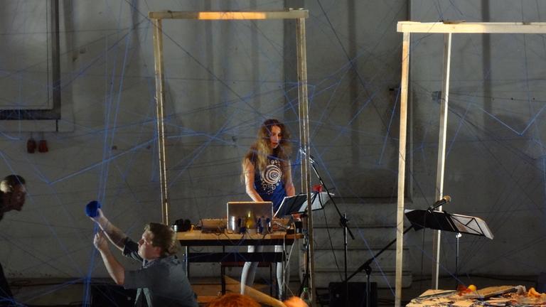 Die Komponistin Anna Korsun steht vor einem Laptop und spielt ein Konzert. Die Komponistin Anna Korsun steht vor einem Laptop und spielt ein Konzert.