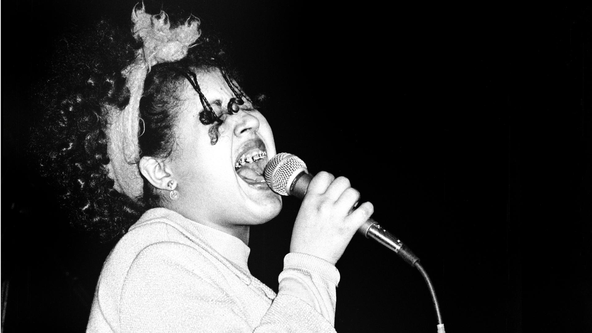 Poly Styrene mit Mikrofon auf der Bühne mit der Band X-Ray Spex. London, 1978. Poly Styrene mit Mikrofon auf der Bühne mit der Band X-Ray Spex. London, 1978.