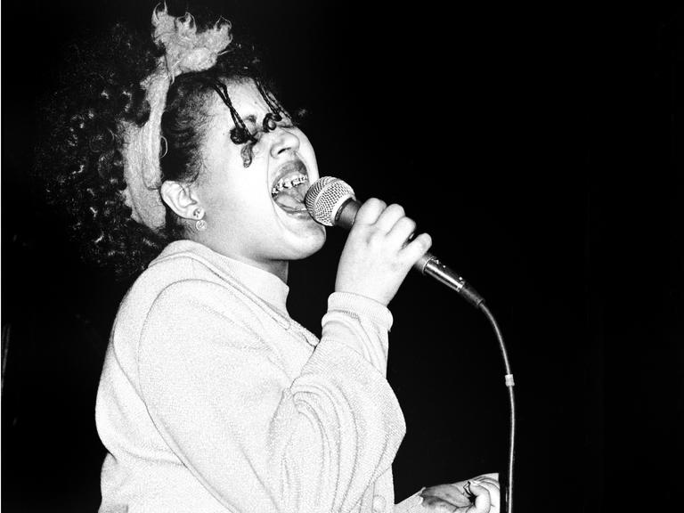 Poly Styrene mit Mikrofon auf der Bühne mit der Band X-Ray Spex. London, 1978.