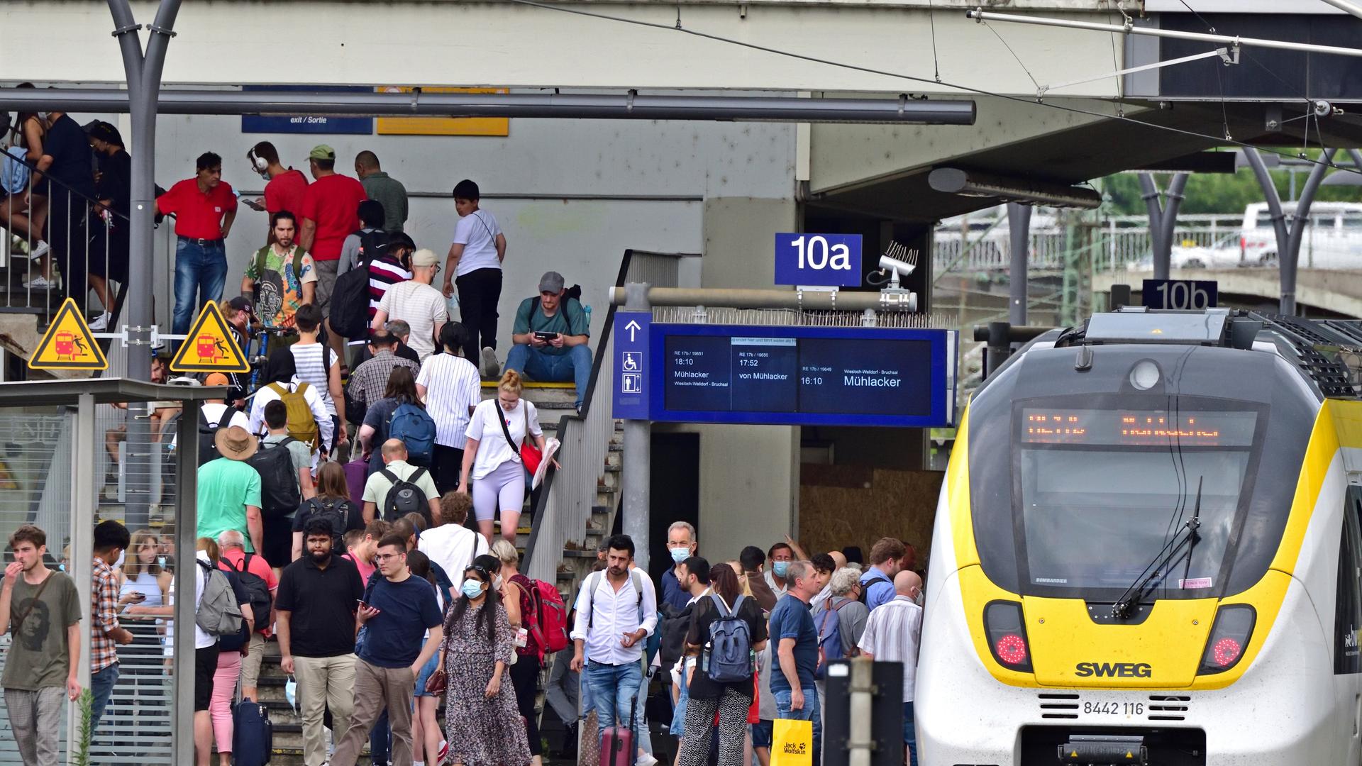 Ein einfahrender Nahverkehrszug steht im Heidelberger Hauptbahnhof. Gedränge auf den Gleisen. Ein einfahrender Nahverkehrszug steht im Heidelberger Hauptbahnhof. Gedränge auf den Gleisen.