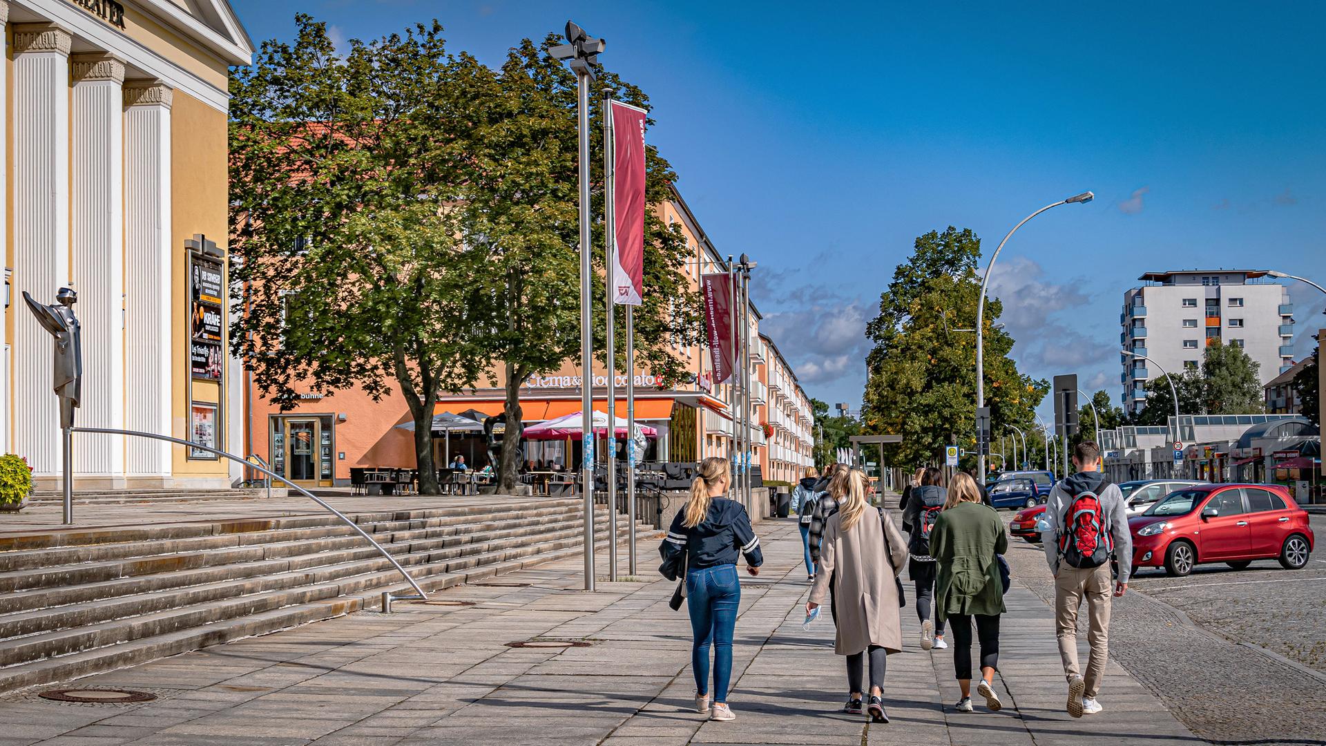 Passanten gehen an einem sonnigen Tag am Friedrich Wolf Theater in Eisenhüttenstadt vorbei. Passanten gehen an einem sonnigen Tag am Friedrich Wolf Theater in Eisenhüttenstadt vorbei.